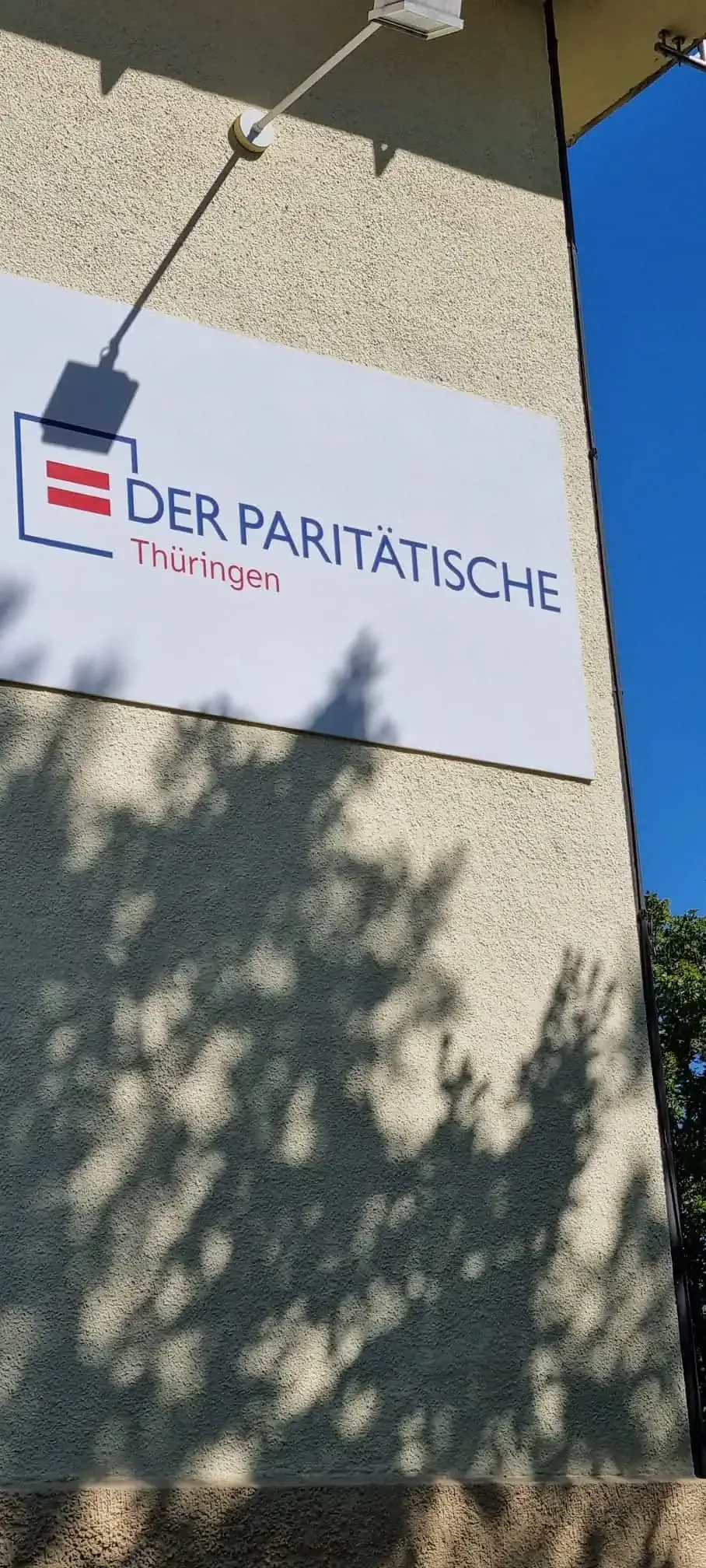 An einer Fassade angebrachtes Firmenschild „Der Paritätische Thüringen“